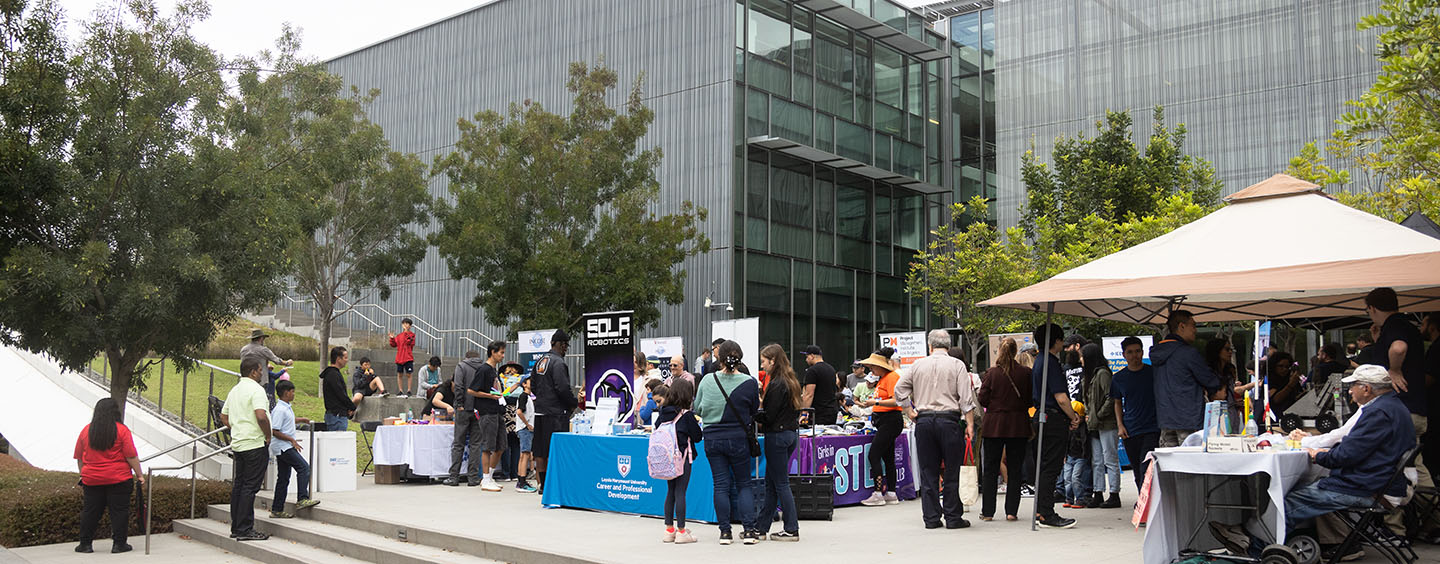 Informational tables and people in Hannon Courtyard